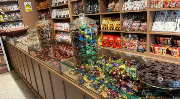 Dulces tentaciones en la fábrica de chocolate Zaragoza. Chocolates, caramelos y bombones en vitrinas y estanterías.