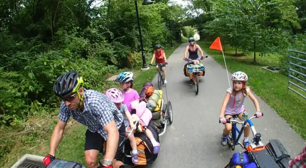 Familia disfrutando de rutas en bici con niños, remolcando equipaje y con niños pedaleando.