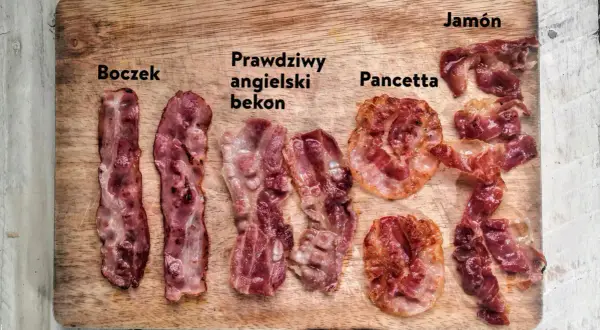 Różne rodzaje bekonu i boczku: boczek, prawdziwy angielski bekon, pancetta i jamón na drewnianej desce.
