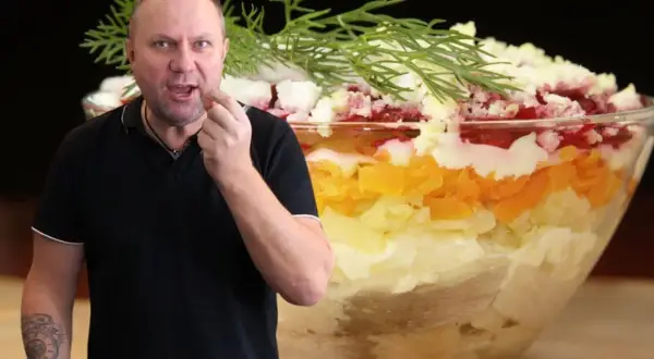 Mężczyzna degustuje warstwową sałatkę, która wygląda jak śledzie pod pierzynką. Przepis na tę pyszną potrawę jest w zasięgu ręki!