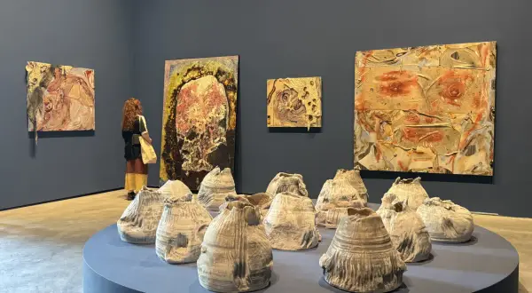 A visitor contemplates abstract artworks and ceramic sculptures at the Venice Biennale 2026.