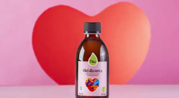 Butelka oleju "Olej dla serca" na tle różowego serca.