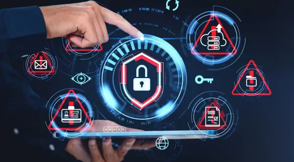 Dłoń wskazuje na ekran z ikonami symbolizującymi cyberbezpieczeństwo: kłódka, klucz, chmura, dokumenty, identyfikator.