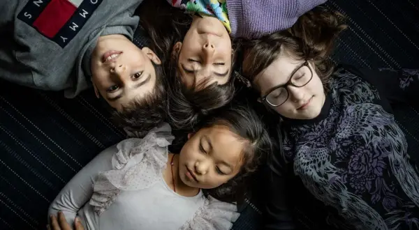 Fyra barn ligger tätt ihop. En 8-åring har svårt att somna, medan de andra verkar sova.