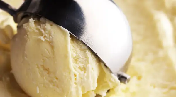 Un cucchiaio raccoglie un cremoso gelato, con un sapore che ricorda il latte condensato.