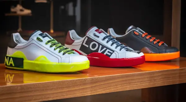 Trzy designerskie sneakersy co to za modele! Białe z neonową podeszwą, czerwone z napisem LOVE i czarne z pomarańczowymi sznurówkami.