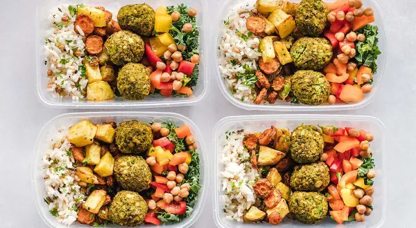 Cztery pojemniki z posiłkami: ryż, pieczone warzywa, falafel i sałatka. Idealne na dietę DASH przepisy.