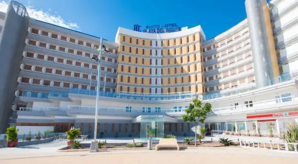 Nowoczesny hotel Suite Hotel Playa del Inglés z charakterystyczną, zakrzywioną fasadą i licznymi balkonami.