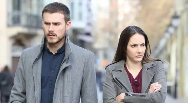 Een man en vrouw lopen met een boze blik uit elkaar. Ze lijken conflict zoekende mensen, elk met hun eigen gedachten.