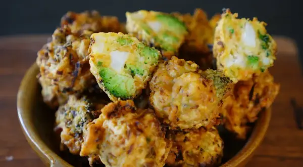 Beignets de légumes croustillants, un délice doré avec des morceaux de brocoli et de pomme de terre bien visibles.