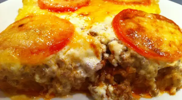 En saftig tacopaj i långpanna med köttfärs, ost och tomatskivor. Perfekt för hela familjen!