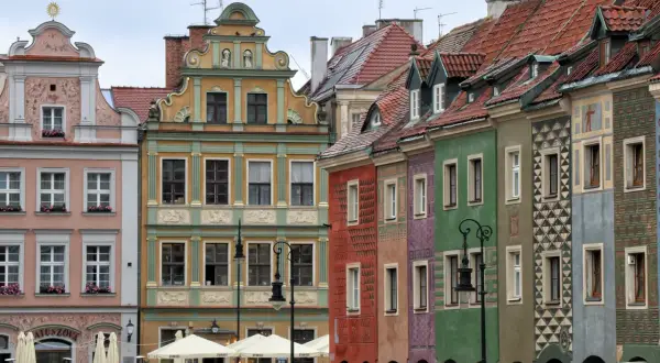 Bunte Häuser am Marktplatz in Posen, Polen. Die Fassaden sind reich verziert und die Dächer mit roten Ziegeln gedeckt.