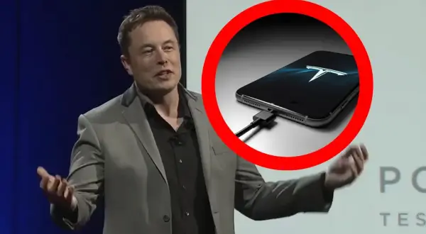 Elon Musk prezentuje telefon z logo Tesli, podłączony do ładowania.