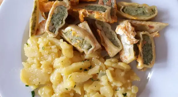 Leckeres Maultaschen Rezept: goldbraun gebratene Maultaschen mit herzhafter Füllung und cremigem Kartoffelsalat, garniert mit frischem Schnittlauch.
