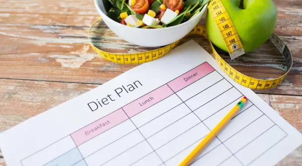 Piano alimentare con mela verde, insalata e metro, per una dieta facile da seguire.