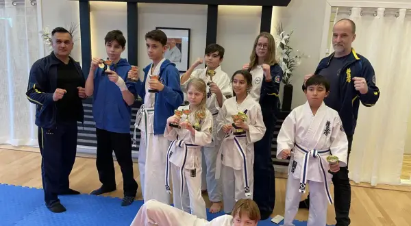 Stolta barn med pokaler efter träning i Oyama Karate Kai. Tränare och elever firar framgångar.