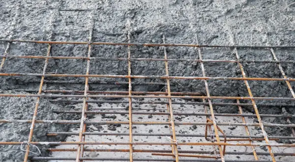 Zbrojenie fundamentów z betonu. Siatka z prętów stalowych czeka na zalanie, by stworzyć solidną podstawę.