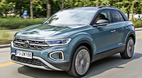 Nowy Volkswagen T-Roc 2026 w kolorze morskim, zgrabny SUV na drodze, gotowy na przygody.