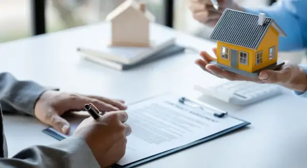 Firma di un contratto di comodato d'uso oneroso con una casa modello in mano.