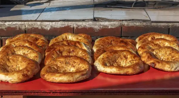 Świeżo upieczone pieczywo gruzińskie, różne rodzaje, z czarnuszką, kuszą apetycznym wyglądem.
