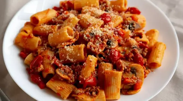 Pyszny przepis na makaron z sosem pomidorowym, grzybami i parmezanem. Idealny na szybki obiad.