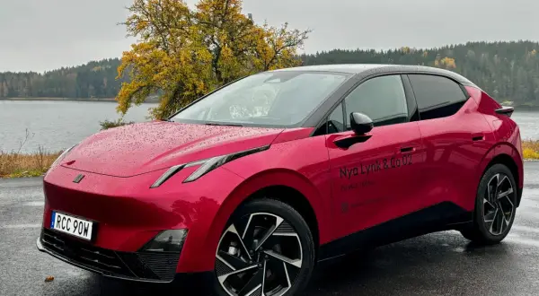Röd elbil parkerad vid en sjö med höstfärger. En perfekt plats för en tco kalkyl.