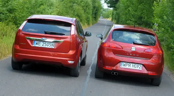 Dwa czerwone samochody jadące obok siebie. Ford Focus i Seat Leon. Czy to wyprzedzanie a wymijanie?