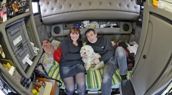 Un couple et leur chien blanc profitent d'un moment de détente dans l'espace cosy de leur camion américain.