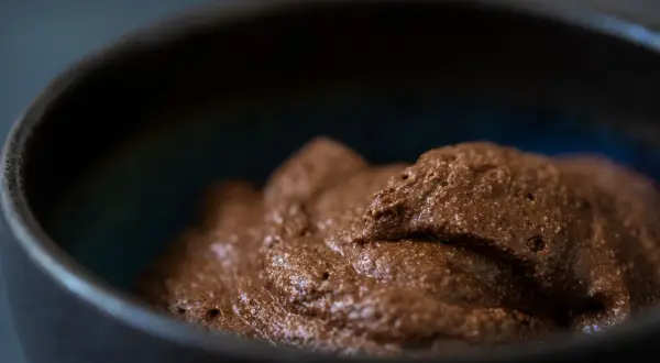 Luftige Mousse au Chocolat in einer dunklen Schale, bereit zum Genießen.
