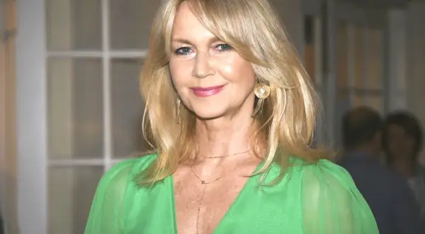 Elegancka kobieta po 60-tce z półdługimi, blond włosami, w zielonej sukience. Idealne fryzury dla pań po 60 włosy półdługie.