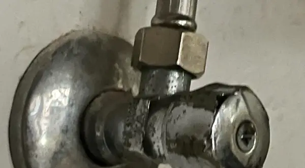 Metalowy zawór wody z uchwytem i śrubą.