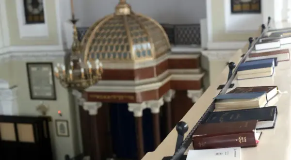 Wnętrze synagogi z księgami na balustradzie. Poznaj zasady ubioru i etykiety, jak zachować się w meczecie i synagodze.
