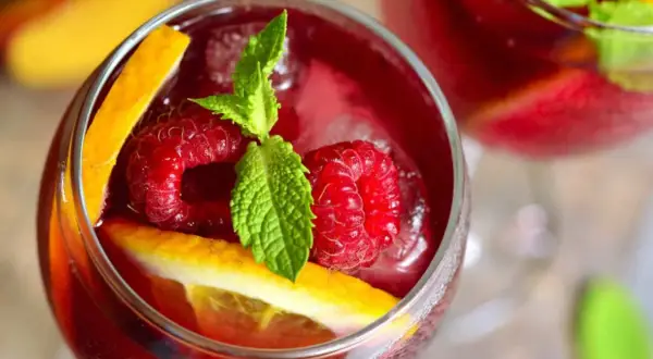 Orzeźwiająca sangria co to? Pyszny napój z malinami, pomarańczą i miętą, idealny na upalne dni.