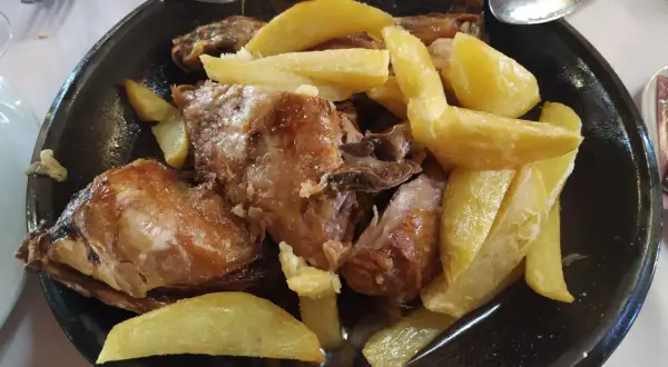 Cordero asado con patatas fritas, un plato típico del rancho el portachuelo.