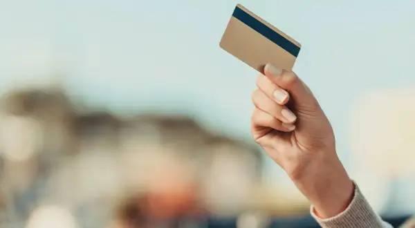 Dłoń trzyma kartę, gotowa do płatności. Sprawdź kurs walut Mastercard przed podróżą.