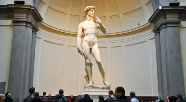 Il David di Michelangelo, capolavoro della Galleria dell'Accademia di Firenze, ammirato da visitatori.