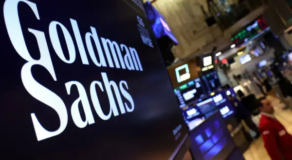 Ekran z napisem Goldman Sachs, w tle giełda i ludzie. Analiza obligacji.
