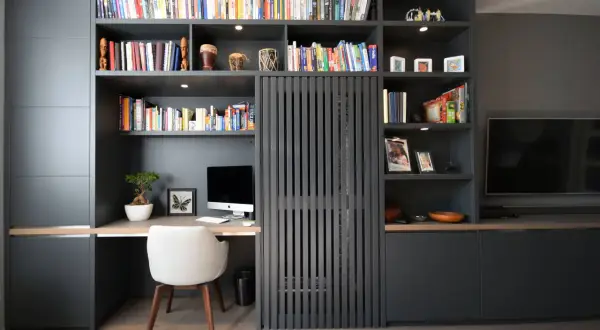 Gemütliche arbeitsecke im wohnzimmer mit Schreibtisch, Computer und Bücherregal.
