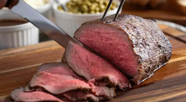 Roast beef succulento affettato, pronto per essere gustato. Una perfetta roast beef ricetta in pentola per un pranzo speciale.