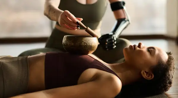 Kobieta z protezą ręki prowadzi sesję dźwiękoterapii. To przykład tego, wellness co to – dbanie o ciało i umysł w harmonii.