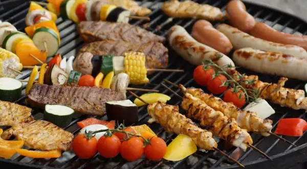 Grill z kiełbaskami, szaszłykami z kurczaka i warzywami, mięsem i kukurydzą.