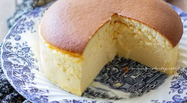 Una soffice torta giapponese, dorata in superficie e chiara all'interno, servita su un piatto decorato con un motivo blu e bianco.