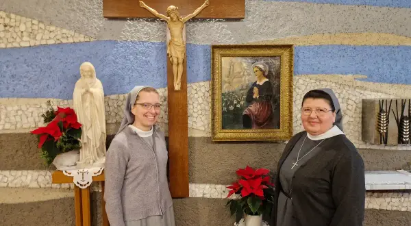 Dwie zakonnice pozują do zdjęcia przy krzyżu i figurze Matki Bożej. 27 stycznia to ważna data dla ich zgromadzenia.