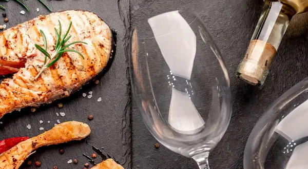 Gegrillter Lachs mit Rosmarin und Pfefferkörnern, bereit für die perfekte Weinbegleitung. Welcher Wein zu Lachs passt, fragst du dich?