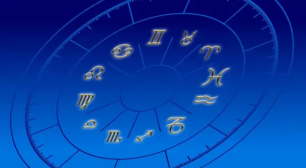Złote symbole zodiaku na niebieskim tle. Praktykowanie magii i horoskopów może wpływać na życie duchowe katolika, odciągając od wiary.