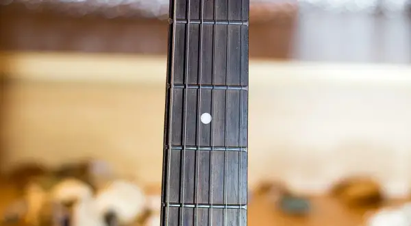 Gryf gitary z progami i progami, gotowy do wykonania najpiękniejszych utworów gitarowych.