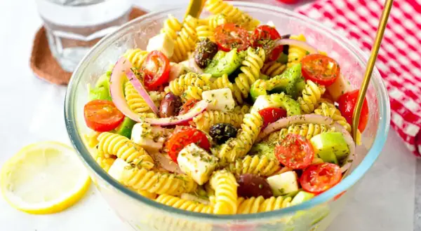 En härlig grekisk pastasallad med fusilli, körsbärstomater, fetaost, oliver och rödlök. Perfekt för en lätt lunch eller middag.