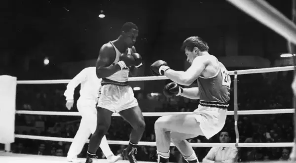 Young Joe Frazier in a boxing match, focused and ready to fight.