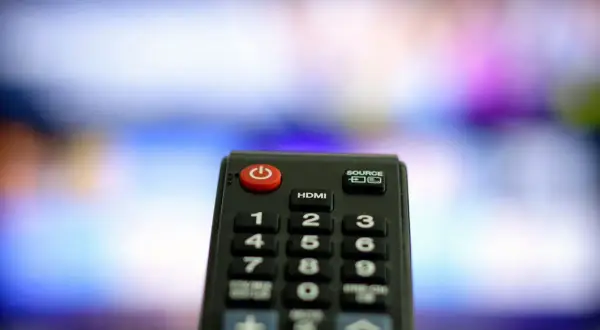 Pilot leży obok, ale jak włączyć telewizor bez pilota? Czerwony przycisk zasilania na pilocie jest kluczem.