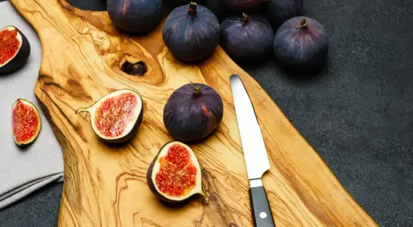 Na desce leżą dojrzałe figi, niektóre przekrojone. Zastanawiasz się, czy pies może jeść figi?